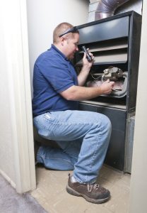 service professional working on the inside of a heating system