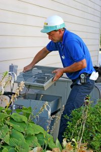 technician working on the outside unit of an air conditioner