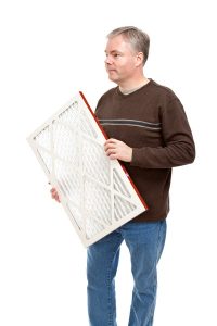 man holding air filter, imposed on white background