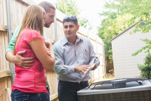 technciian-talking-about-air-conditioner-with-homeowners