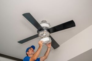 electrician-removing-cover-from-light-on-ceiling-fan